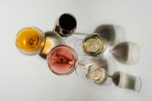Overhead view of diverse wine glasses casting artistic shadows on a white surface.